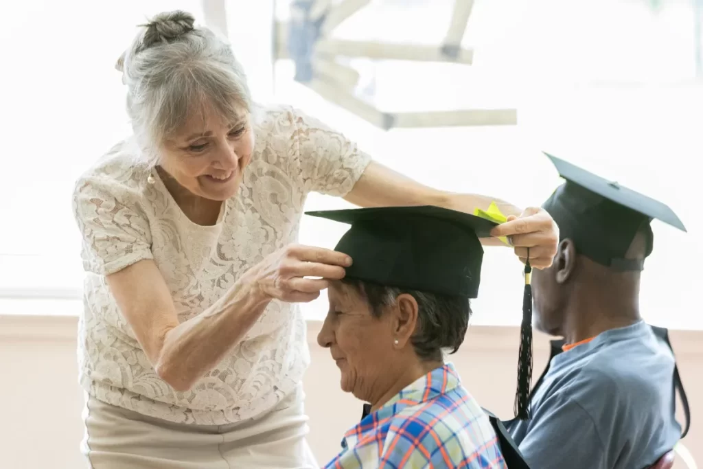 Diane Doonan, vice-president of the LaSalle D&D 50+ Centre, adjusts Patricia Hernandez's cap before the start of the graduation ceremony. "Our seniors, you have no idea how eager they are — and always have been — to speak French," she said. (Tim Snow / Montreal Gazette)